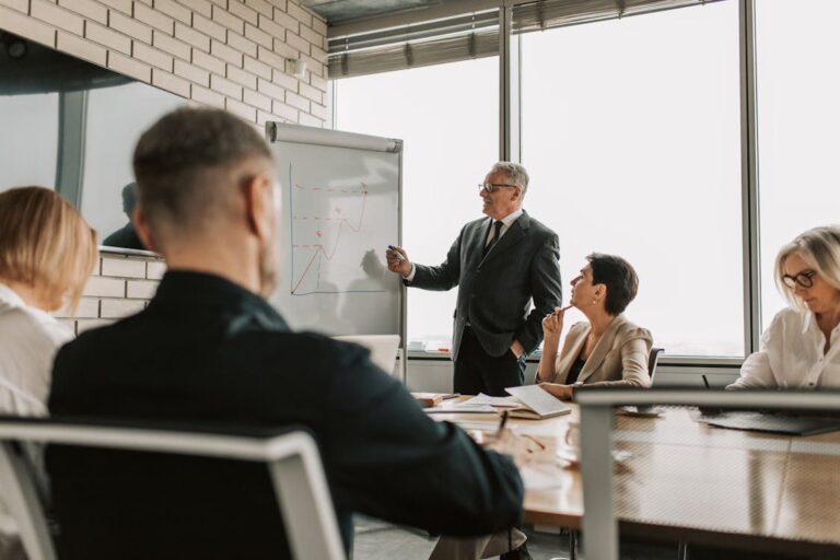 Consultor apresentando gráfico de crescimento em whiteboard para equipe em reunião estratégica B2B