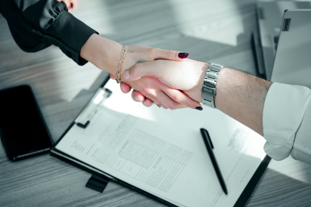 Aperto de maos sobre clipboard com contrato em reuniao B2B