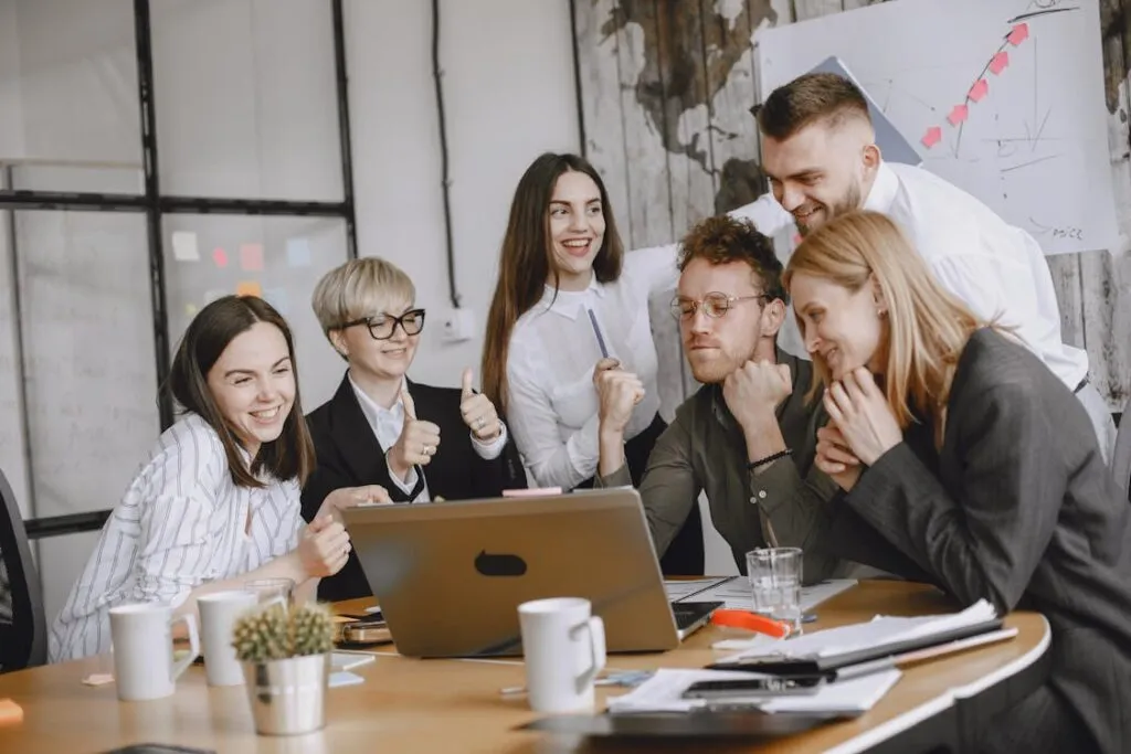 Equipe colaborando na criacao de conteudo comercial em ambiente positivo