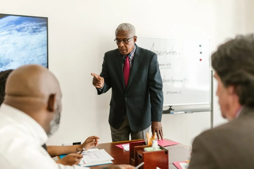 Líder sênior conversando com equipe em reunião comercial