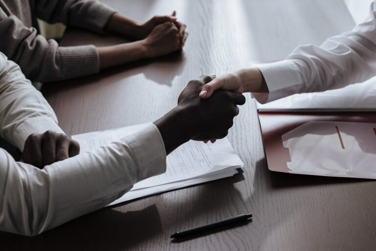 Tres executivos em negociacao complexa B2B com documentos