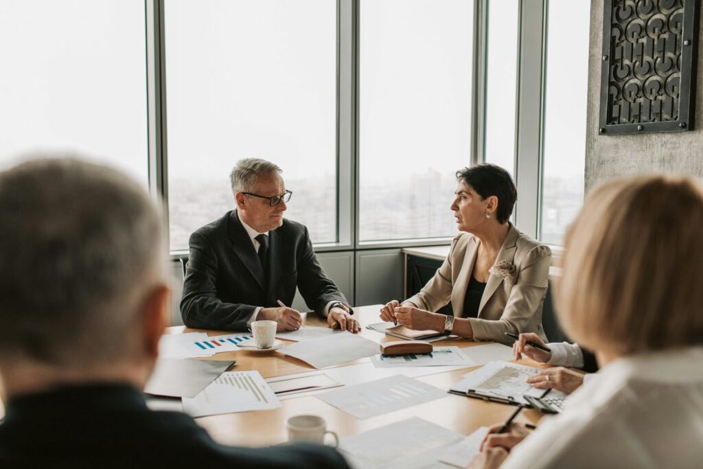Executivos em reuniao estrategica discutindo documentos na sala de reuniao