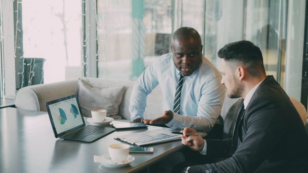 Executivos analisando dados estrategicos em reuniao de vendas enterprise
