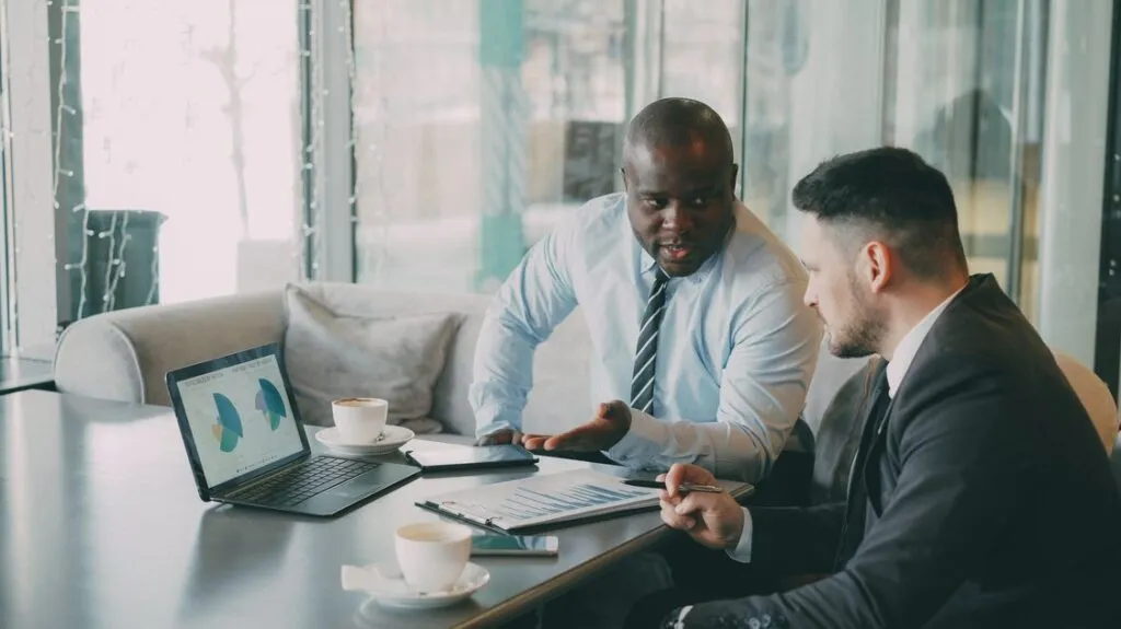 Executivos analisando dados estrategicos em reuniao de vendas enterprise