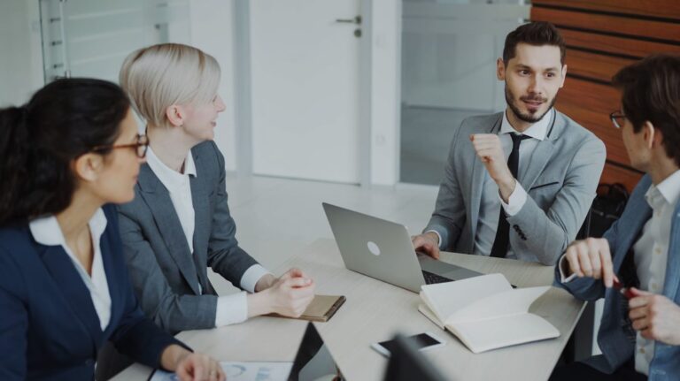 Reuniao de consultoria comercial entre quatro profissionais B2B em escritorio moderno