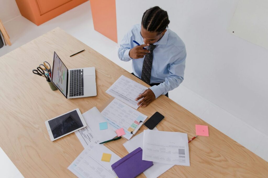 Executivo analisando documentos e relatorios sobre mesa de trabalho