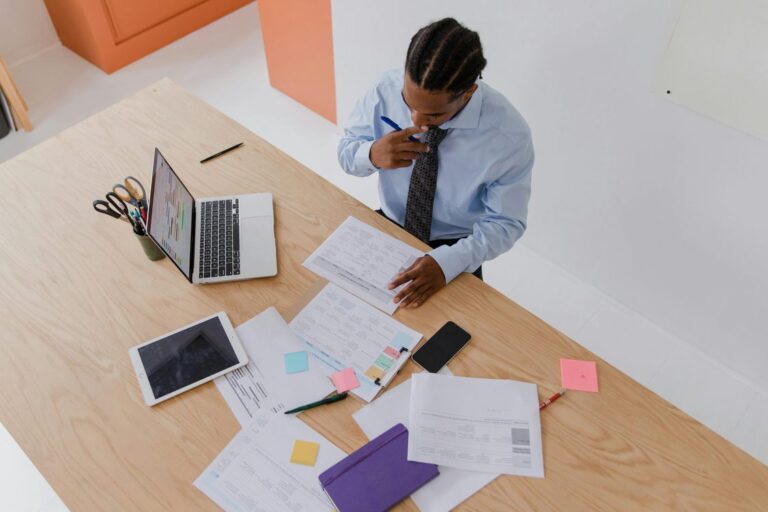 Executivo analisando documentos e relatorios sobre mesa de trabalho