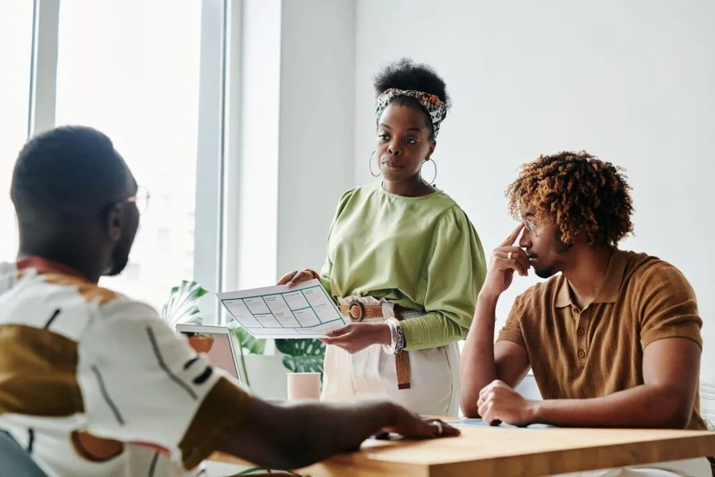 Profissional apresentando relatório de dados para equipe diversa em reunião de negócios
