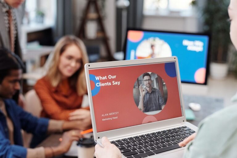 Customer Success Manager apresentando feedback de clientes em laptop para equipe