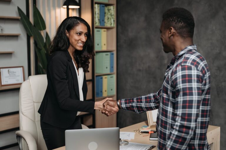 Profissional de customer success fechando parceria com representante de vendas em escritório