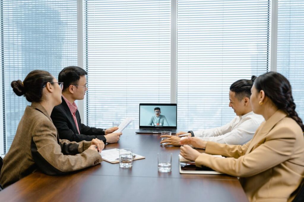 Equipe comercial B2B em reunião com videochamada no laptop conduzindo abordagem que gera reunião com o prospect
