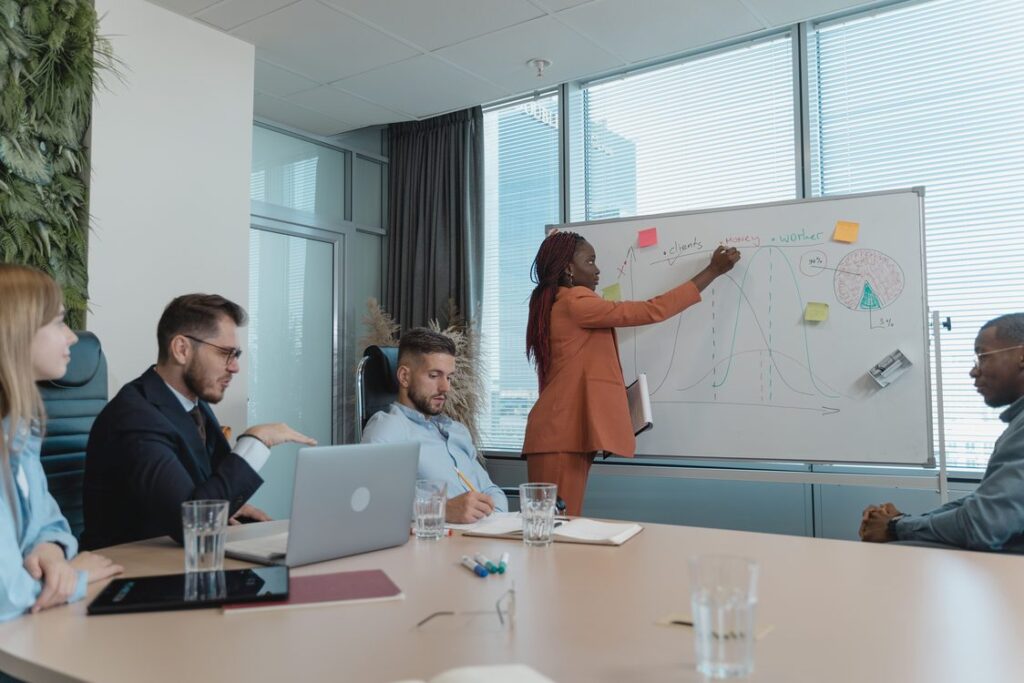 Executiva apresenta gráficos de planejamento comercial para time diverso em sala de reunião