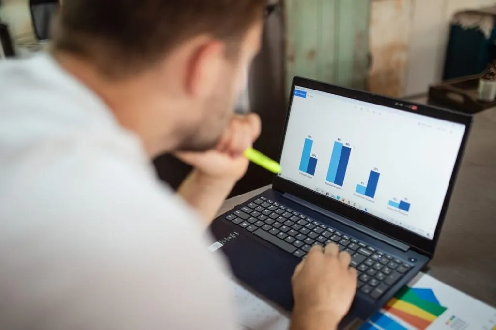 Profissional analisando um gráfico de barras no laptop