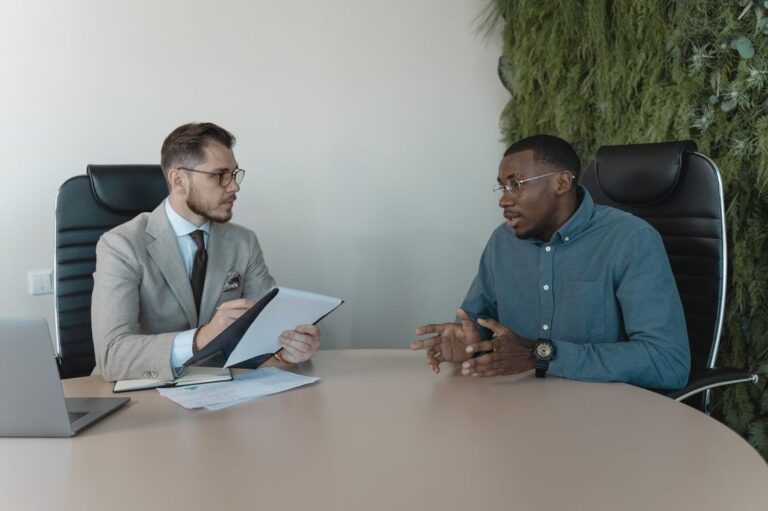 Gestor entrevistando um candidato a vendedor em mesa de reunião