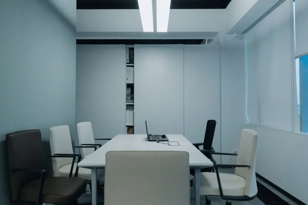 Sala de reunião vazia com notebook aberto sobre a mesa